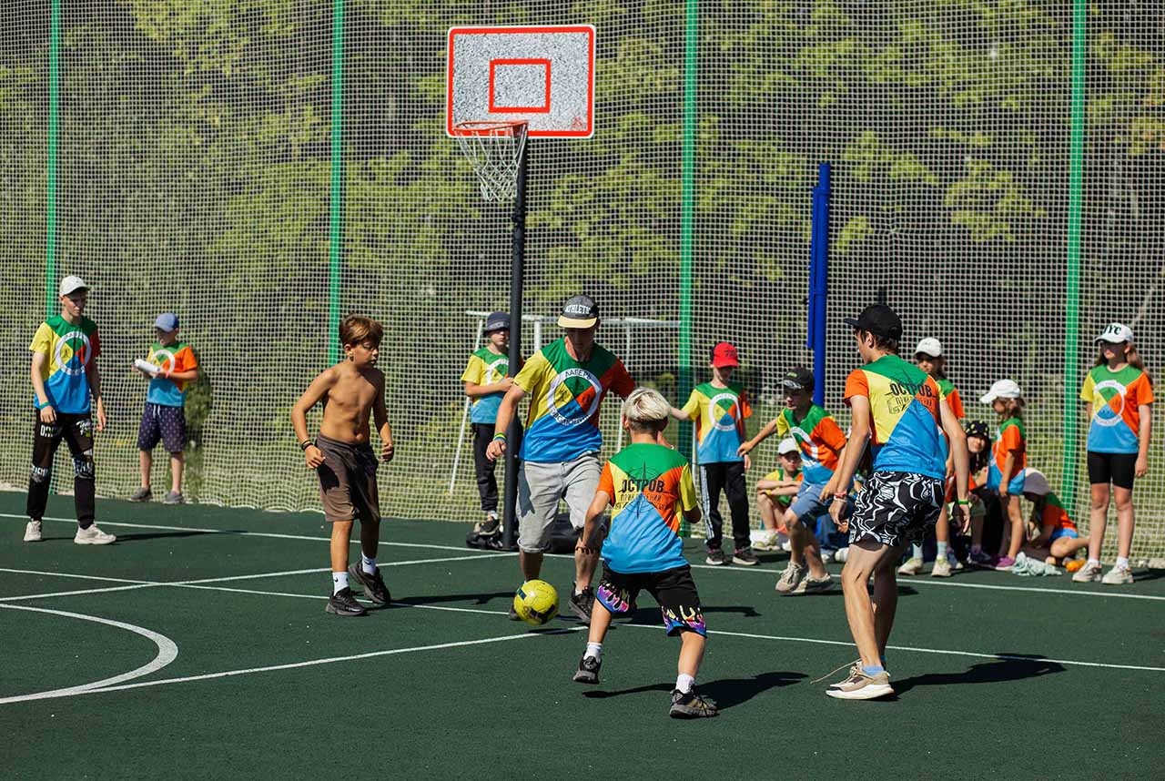 Игра в футбол на спортивной площадке